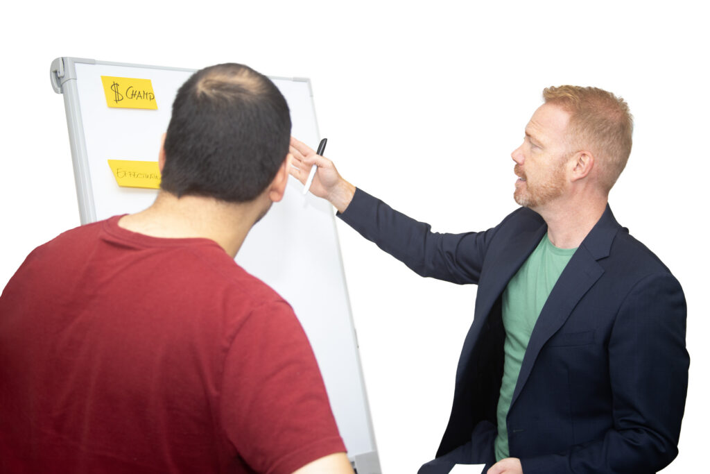 Dr. Kai Bruns berät einen Teilnehmer am Whiteboard